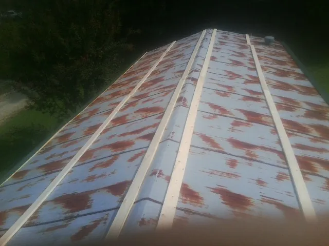 Rusted metal roof panels with new wood purlins before replacement — Storm Damage Roof Repair in Dutton by Roofing Brothers